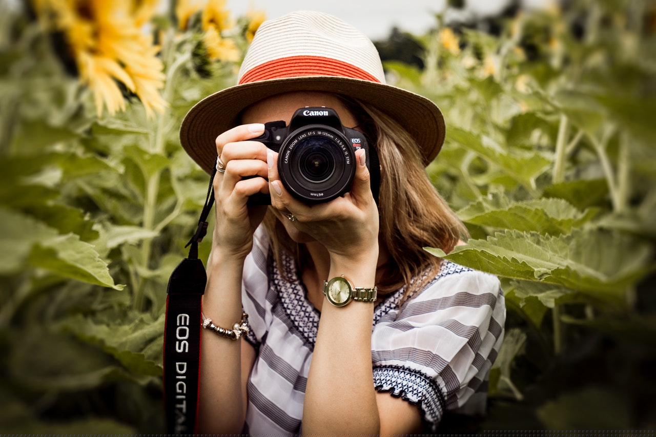 selective focus photography of woman holding dslr camera 1264210