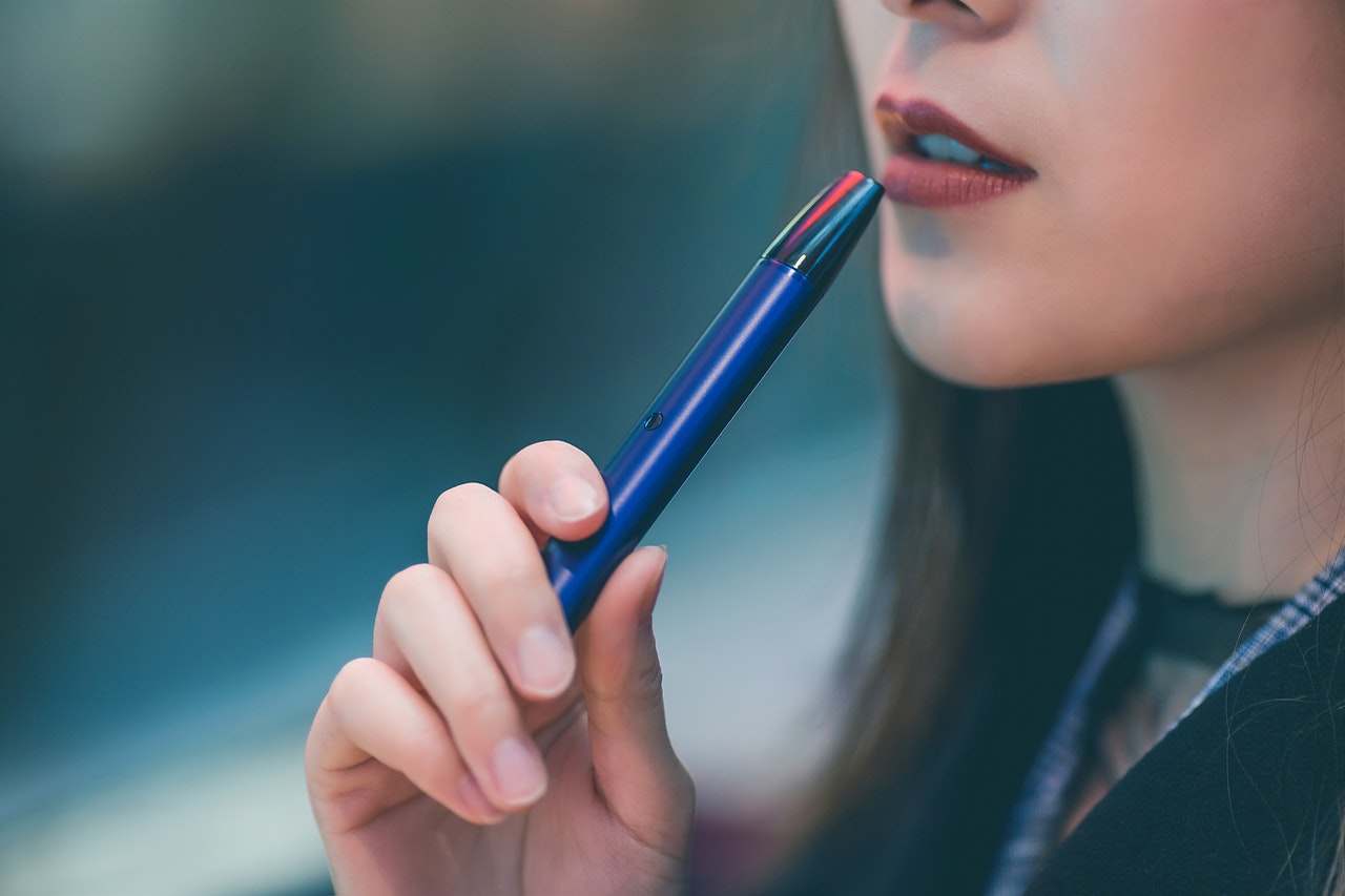 woman holding blue vape 1930678