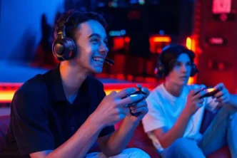two teen friends headphones are playing game console using gamepads smiling 1268 25912