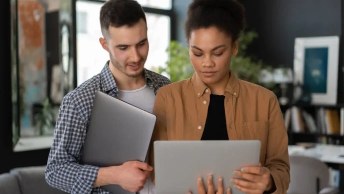 Two people holding grey tablets